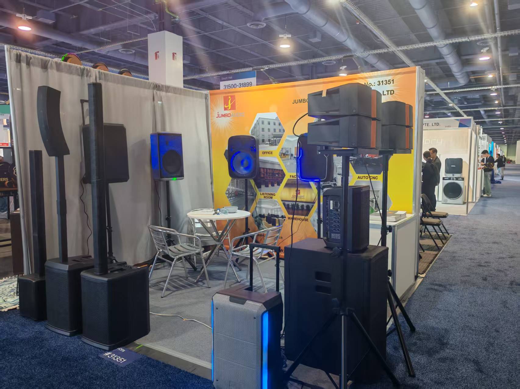 Professional audio equipment exhibition booth showcasing line array speakers, stage monitors, and sound systems at a global trade show