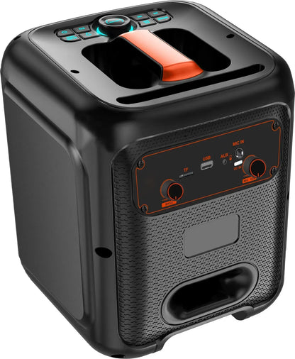 Three-quarter view of a black and orange portable Bluetooth speaker, showing the side control panel with red-trimmed knobs labeled 'VOLUME' and 'MIC VOL', USB and AUX ports, a handle cutout on top, and a carrying handle on the side