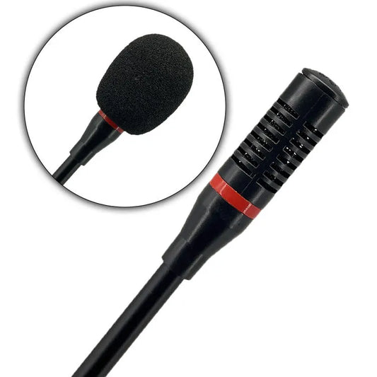 Close-up detail of a professional microphone head featuring a black metal grille, a distinctive red accent ring, and an internal foam windscreen for noise reduction.