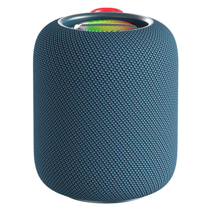 A dark blue cylindrical portable speaker with a textured, woven fabric exterior and a visible colorful RGB light ring at the top, partially obscured by a bright red fabric loop handle.