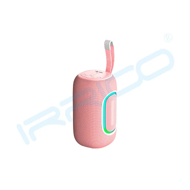A pink cylindrical portable speaker with a textured fabric body, a glowing cyan and green oval light accent on the side, a top control panel, and a pink fabric carrying strap with a white accent