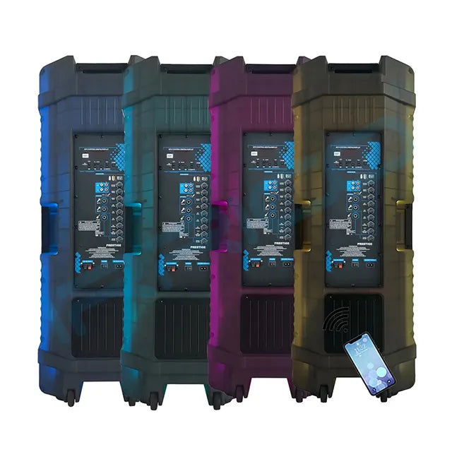 Four large, rugged portable speaker systems lined up side-by-side, each featuring a prominent front control panel with numerous knobs and digital displays, glowing with blue LED lights, and a smartphone placed on the ground in front of the rightmost speaker displaying a music app interface