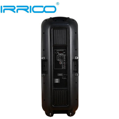 Rear view of a tall, black portable speaker with a rectangular control panel featuring various input/output ports, adjustment knobs, and indicator lights, equipped with wheels and a handle for mobility.