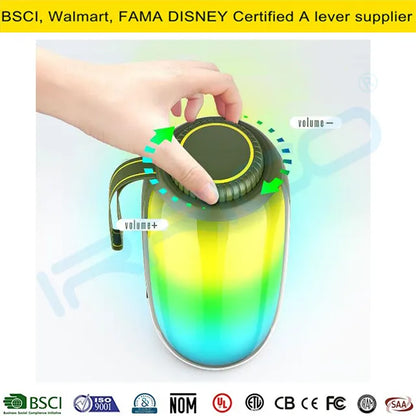A hand pressing a button on top of a portable cylindrical speaker with a green-to-yellow gradient light effect, featuring a side handle and labeled volume adjustment graphics.