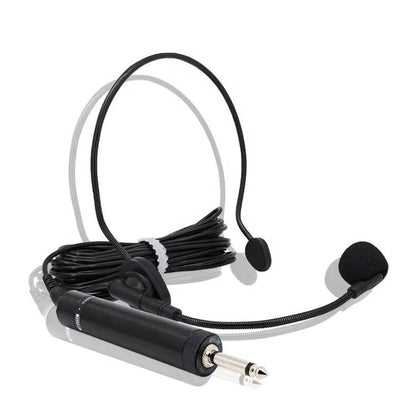 Headworn dual-ear microphone system featuring two foam-covered earpieces on a curved headband, a flexible gooseneck microphone boom, and an inline cylindrical amplifier box with a gold 3.5mm jack output.