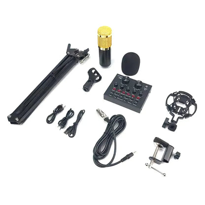 A complete podcasting and streaming kit laid out on a white background, featuring a gold-and-black condenser microphone, a foldable tripod desk stand, a V8 live sound card with various control knobs and buttons, a shock mount, a pop filter, and several audio cables.